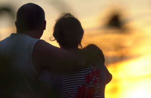 Couple bereaved hugging sunset