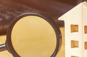 Wooden House And Magnifying Glass