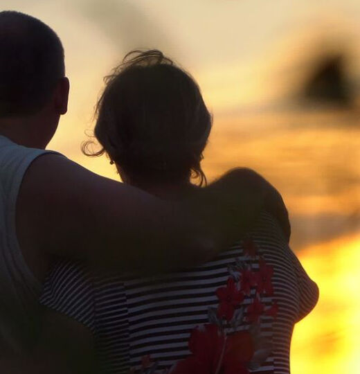 Couple bereaved hugging sunset