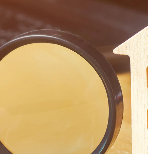 Wooden House And Magnifying Glass