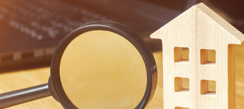 Wooden House And Magnifying Glass