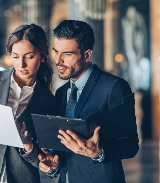 Business man & woman talking looking at documents