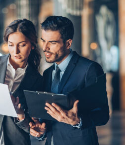 Business man & woman talking looking at documents