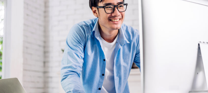 bigstock Young Smiling Asian Man Using  465612805