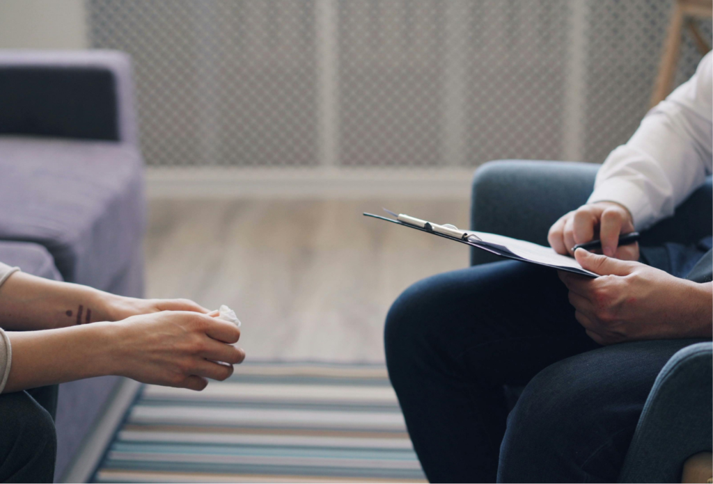 A man and woman sitting in a chair talking to each other