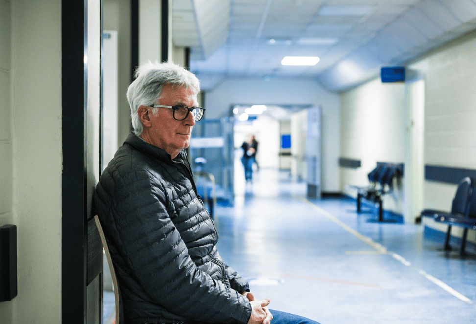 Man sitting in hospital corridor
