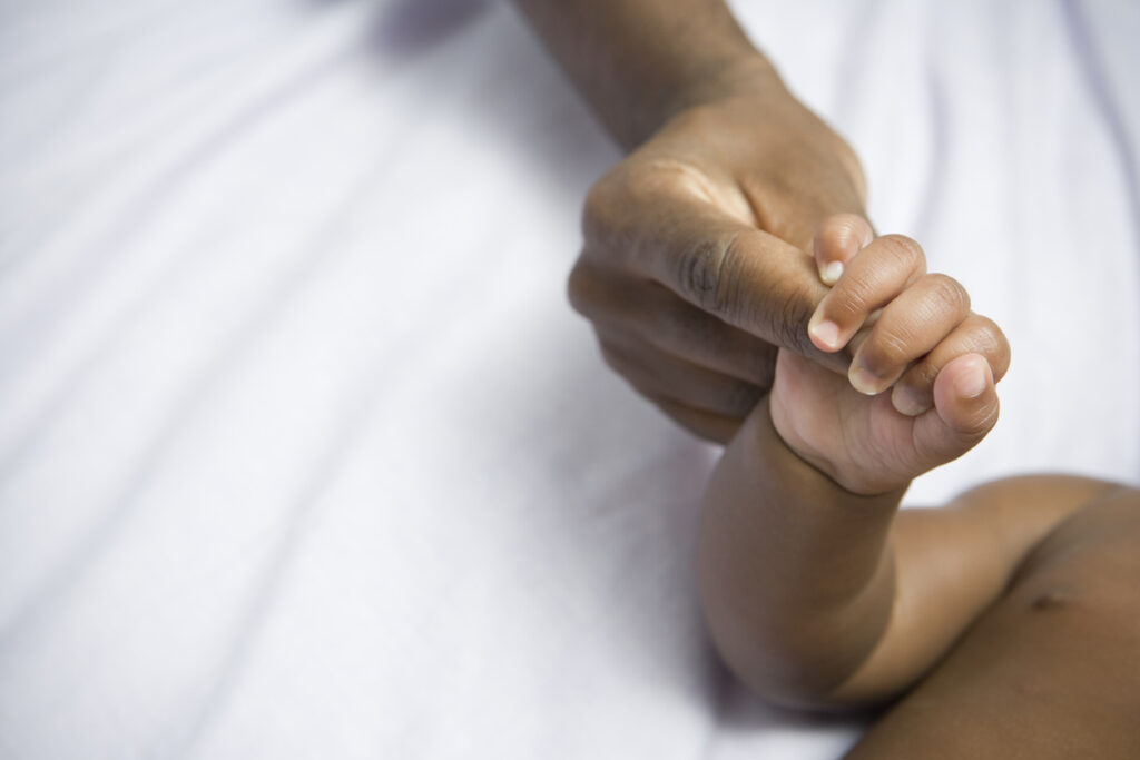 baby holding mums hand