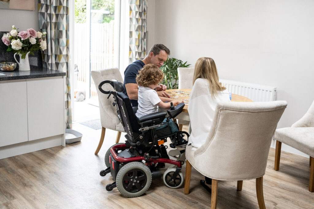 child in wheelchair with parents
