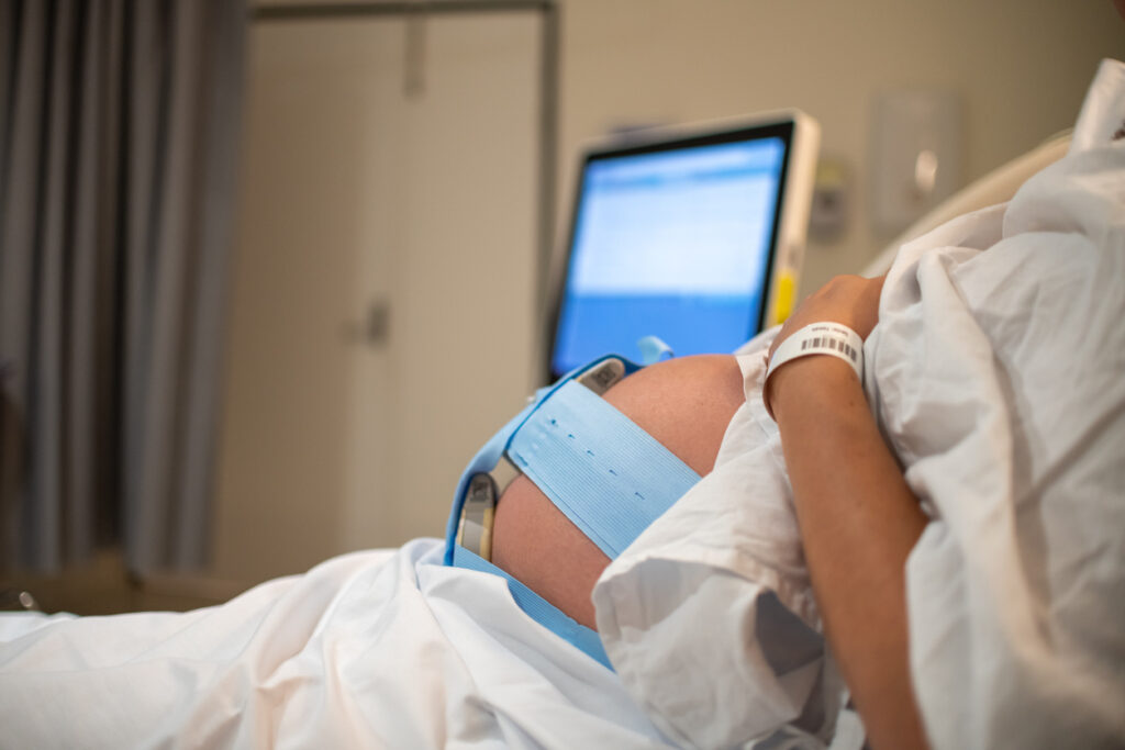 A midwife or clinician checking a CTG monitor