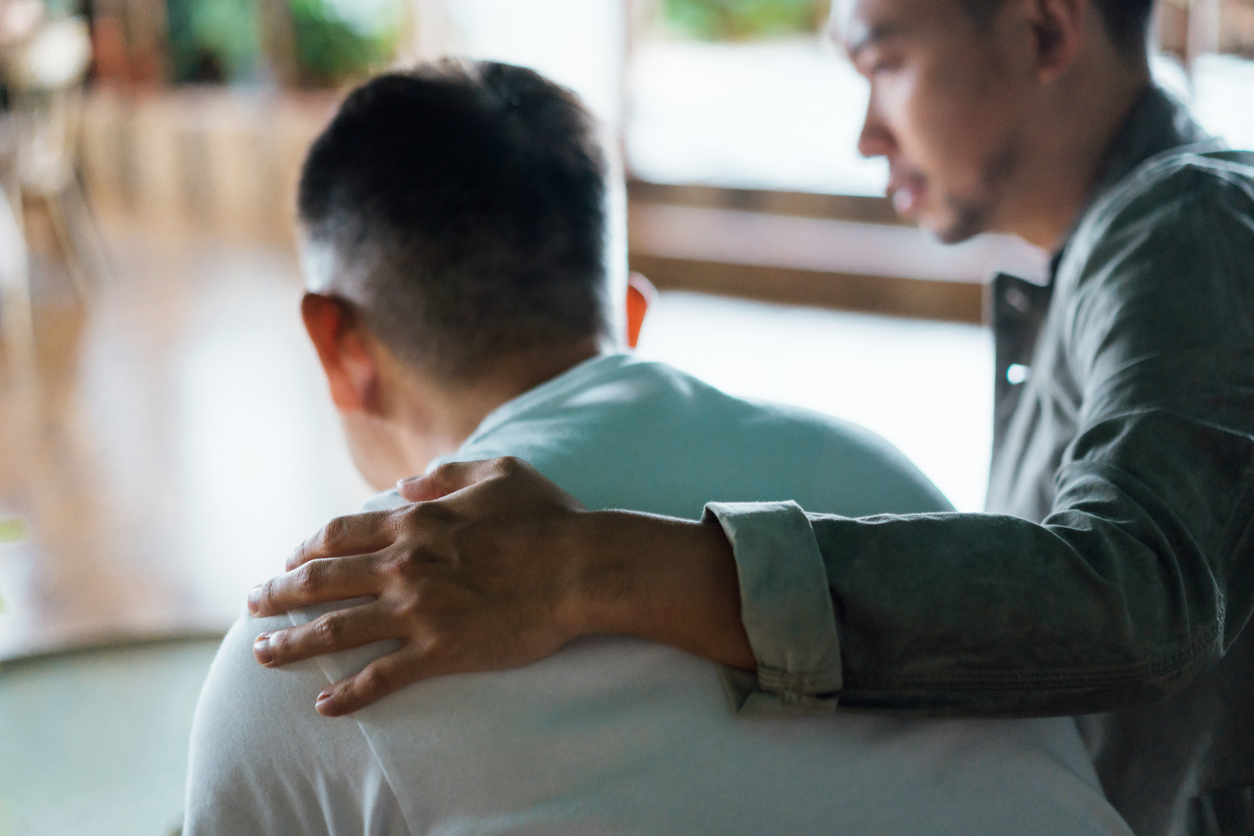 man with hand on back